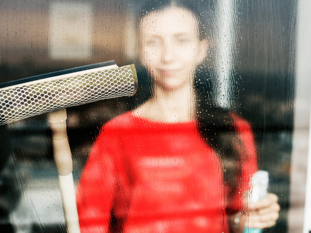 Woman trying to clean Hard Water Stains on Windows